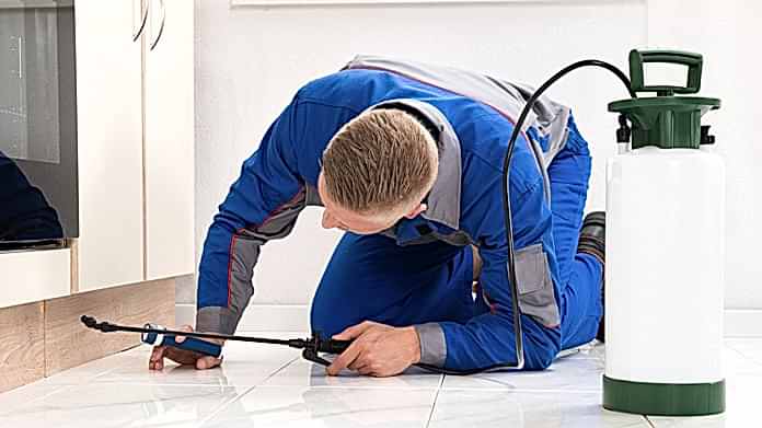 Pest Control Center technician treating a home exterior